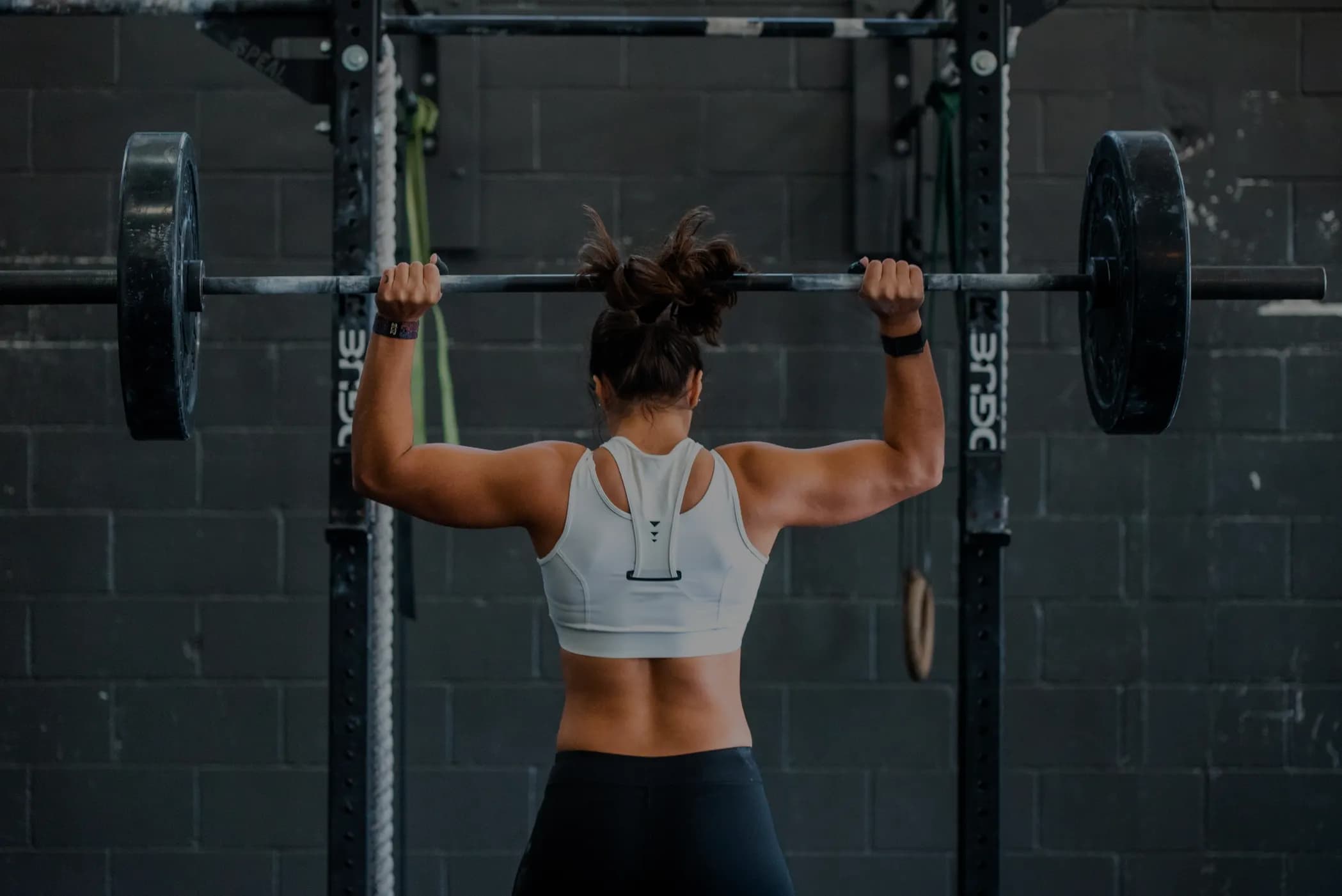 Athlète en position overhead avec une barre chargée chez Fit Factory